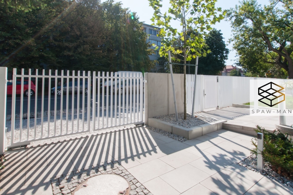 Nowoczesne ogrodzenie z pionowym wypełnieniem w kolorze białym.