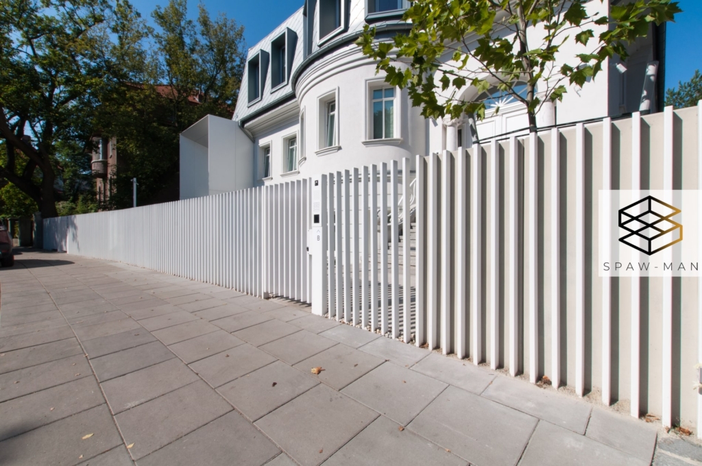 Nowoczesne ogrodzenie z pionowym wypełnieniem w kolorze białym.