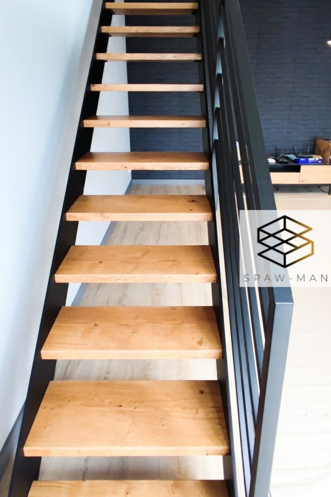 Loftowe schody proste z policzkami pełnymi, stopniami z drewna dębowego oraz balustradą z poziomym wypełnieniem.