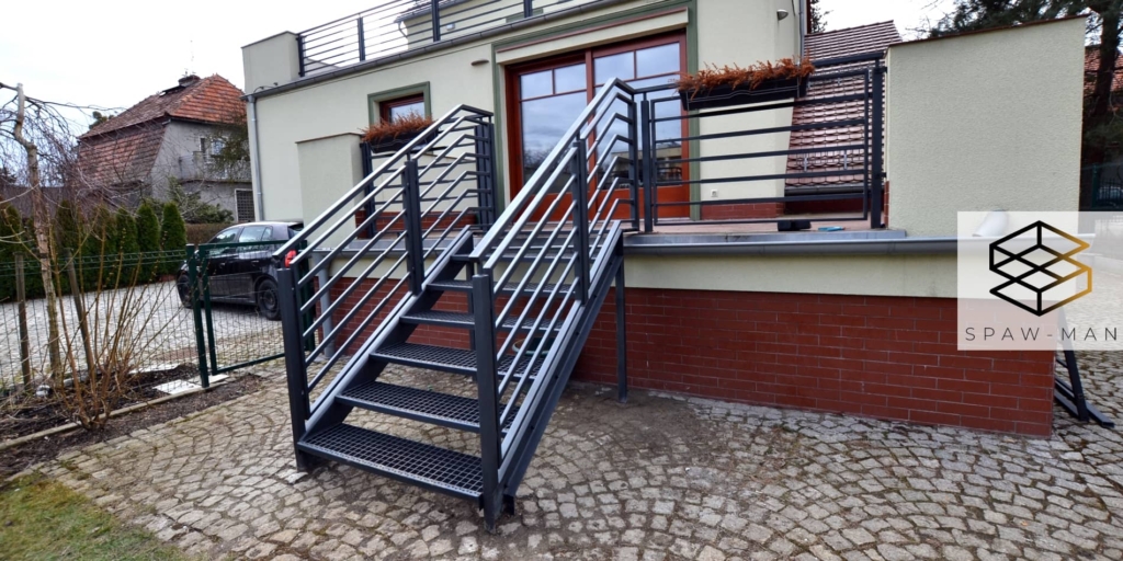 Stalowe schody tarasowe ze stopniami z kraty Wema oraz balustradą z poziomym wypełnieniem z profili kwadratowych.